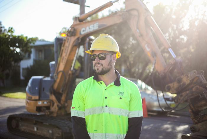 Employee standing in front of a tractor.