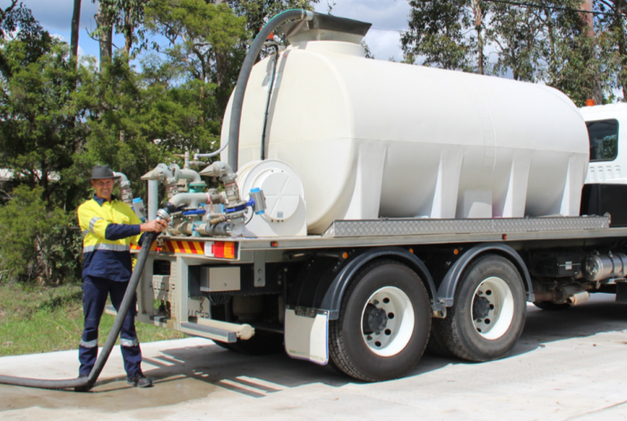 Employee standing with a water truck