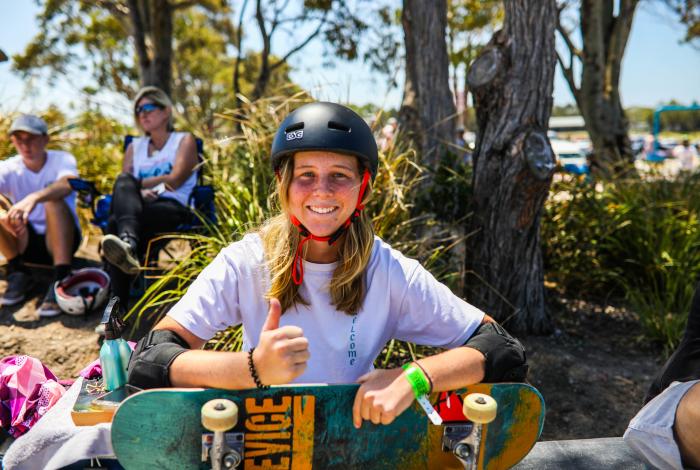 Photo of young person seated and holding their skate board
